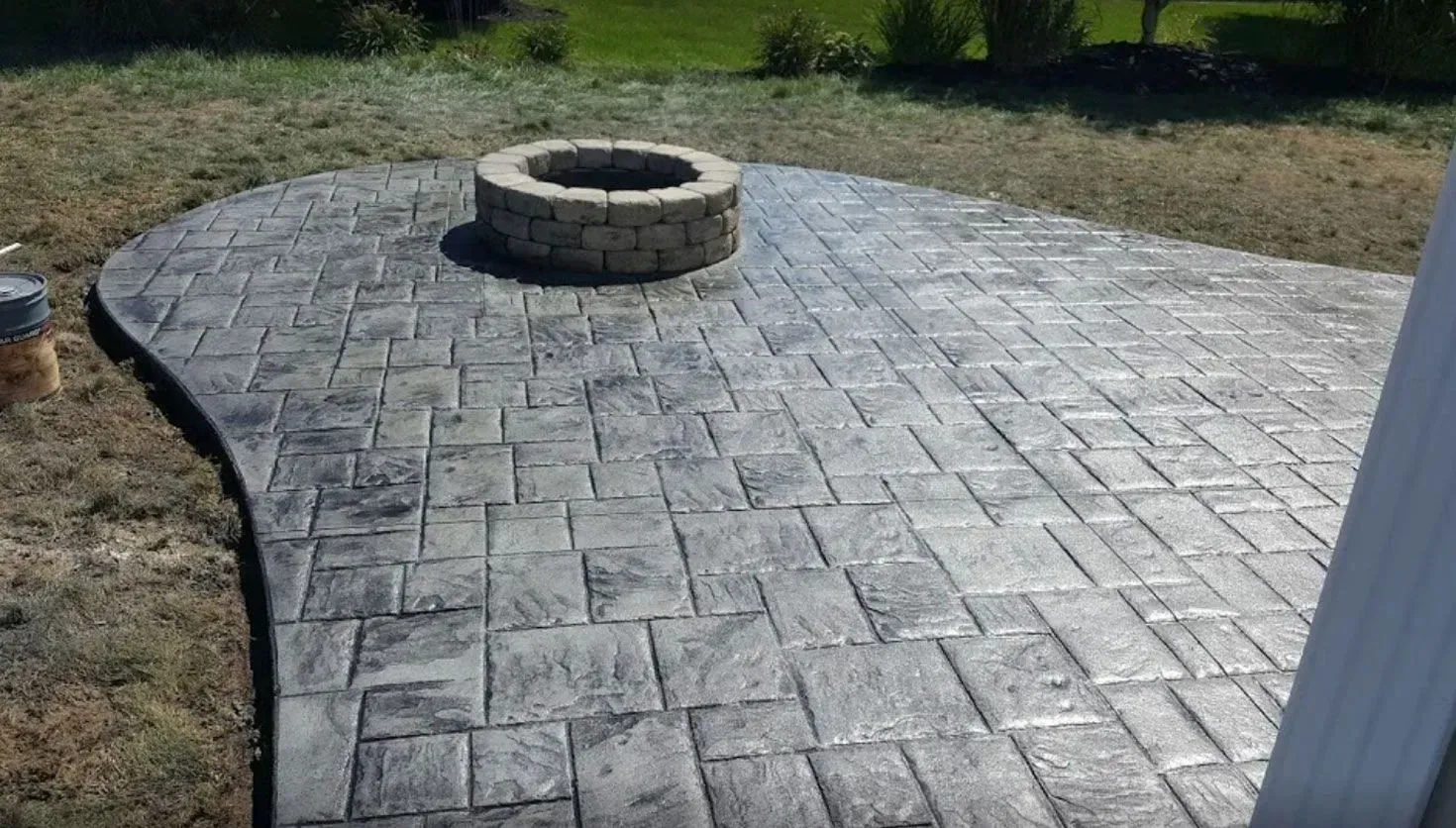 Stone stamped concrete patio with a brick fire pit.