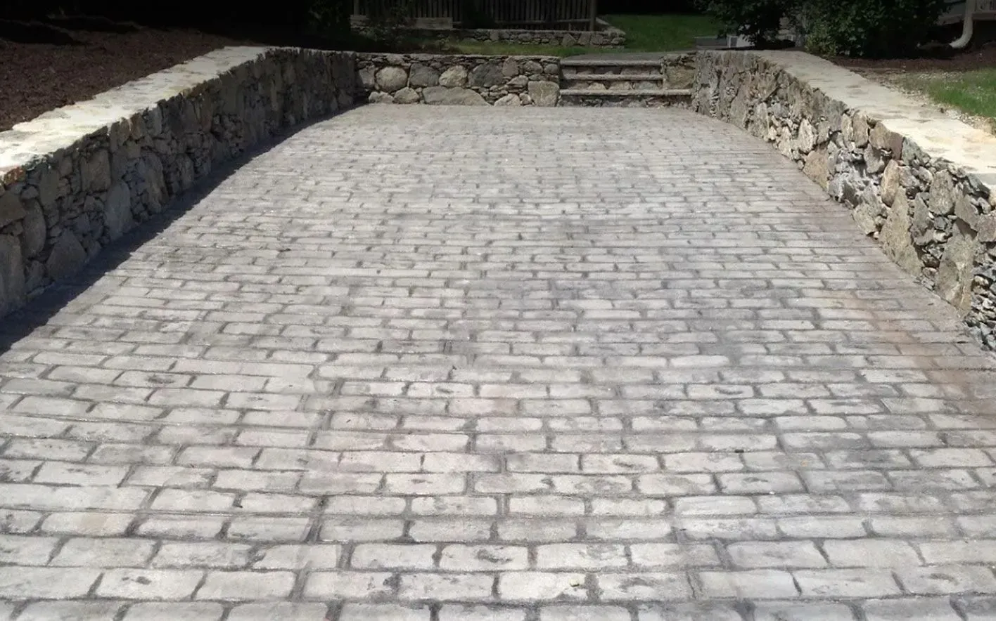 Brick paved driveway with stone retaining walls.
