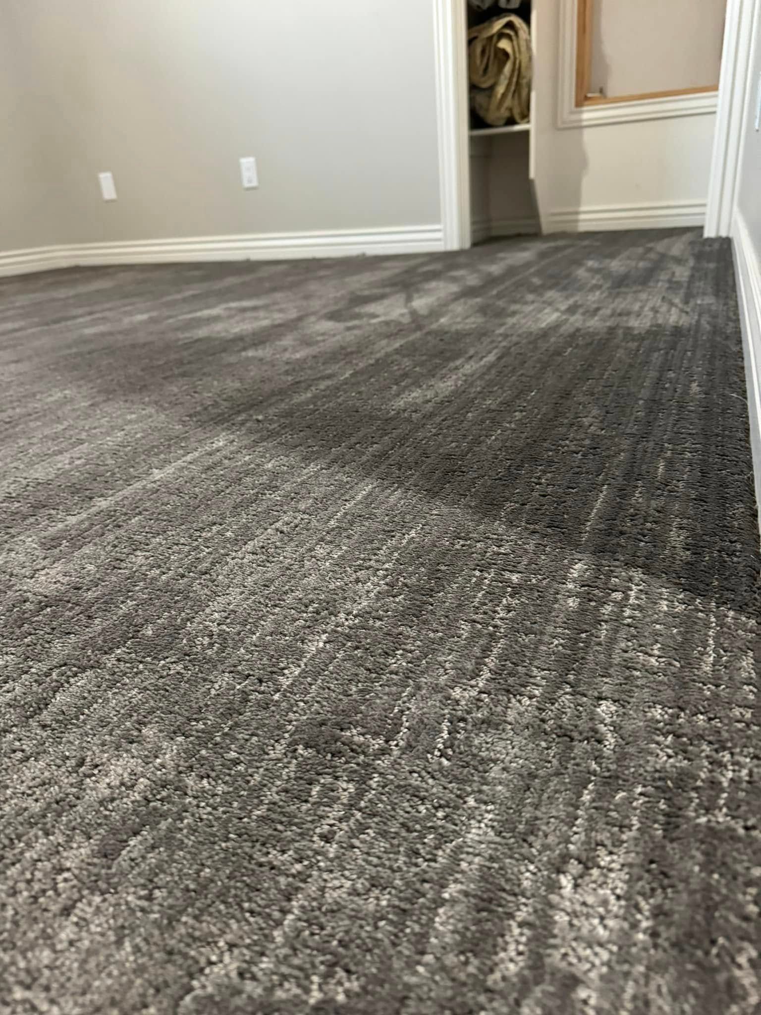 Gray carpeted room with walls and a doorway to a closet or hallway