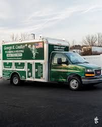Green medical/dental service truck parked on a road, with clinic branding and staff portraits on the side.