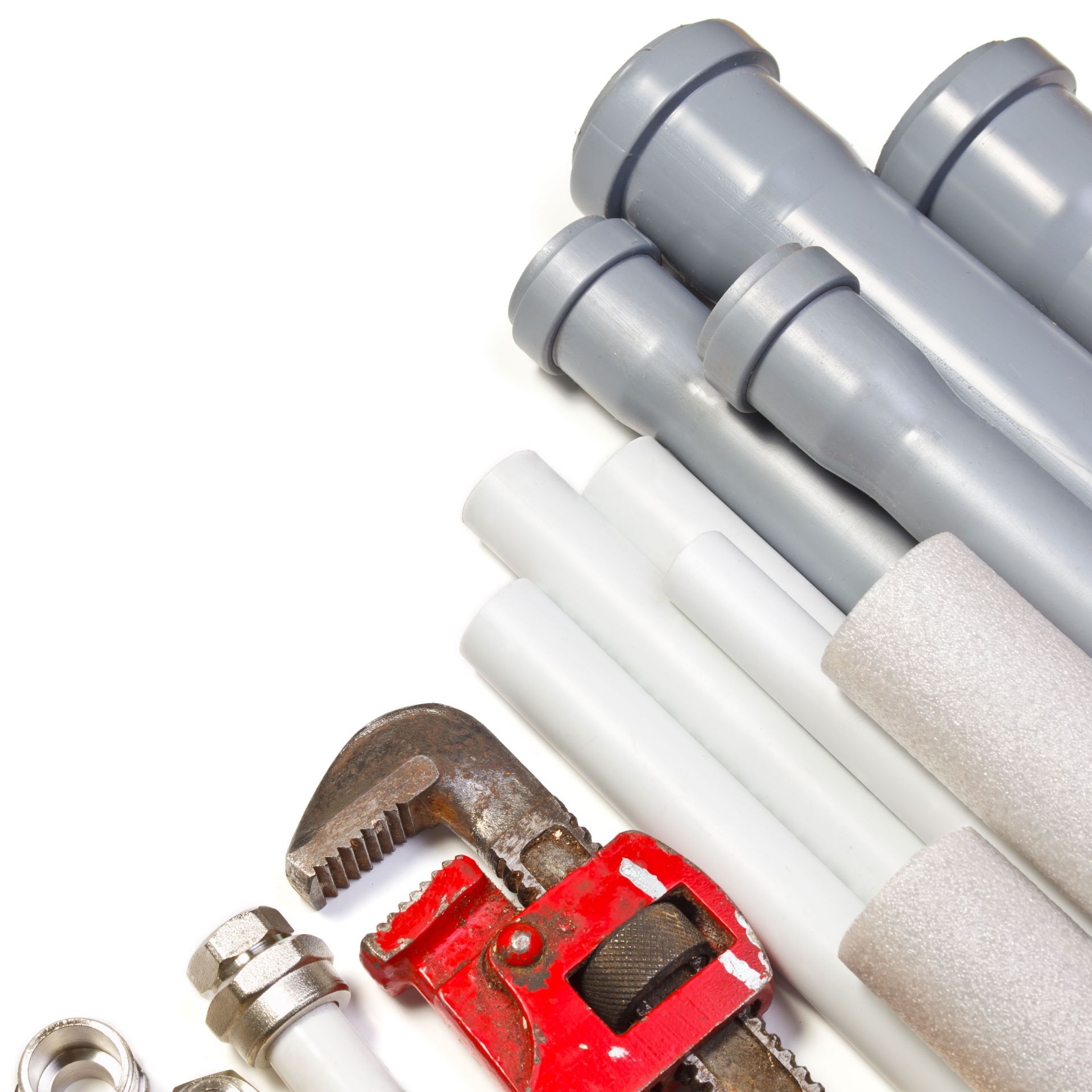 Assorted plumbing tools and pipe fittings on a white background