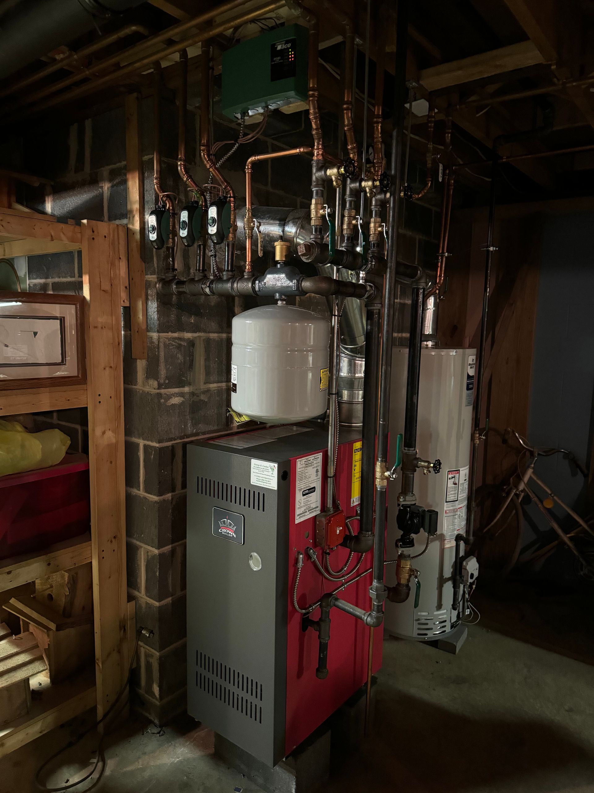 Old furnace and boiler equipment in a basement utility room with exposed pipes and wiring
