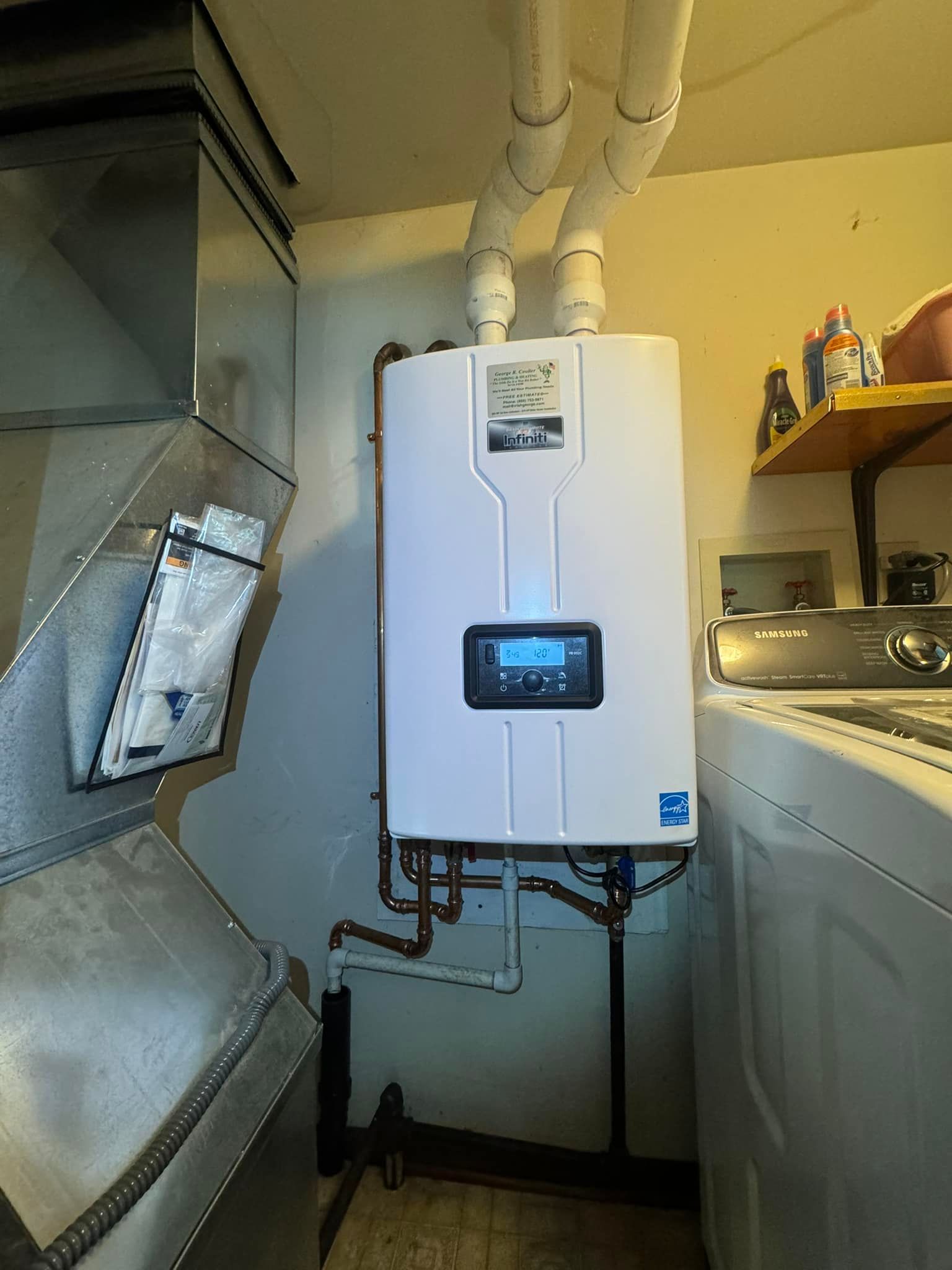 White tankless water heater mounted on a wall in a basement utility area with visible pipes and vents.