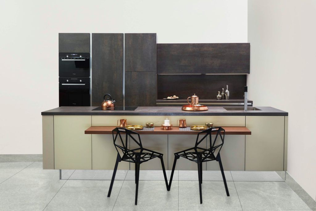 Modern kitchen with dark cabinets, a long island, and two black chairs at a small table.