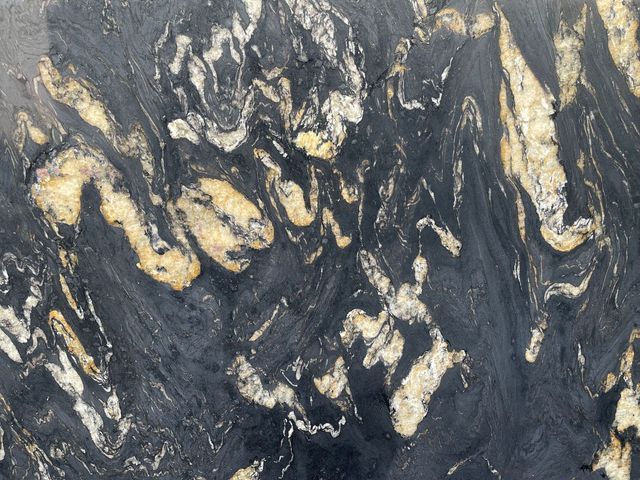 A close up of a black and gold marble counter top