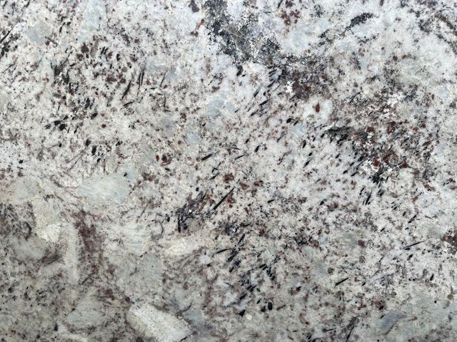 A close up of a white granite counter top.