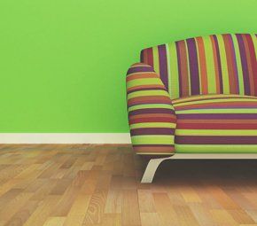 A colorful striped sofa against a bright neon green wall