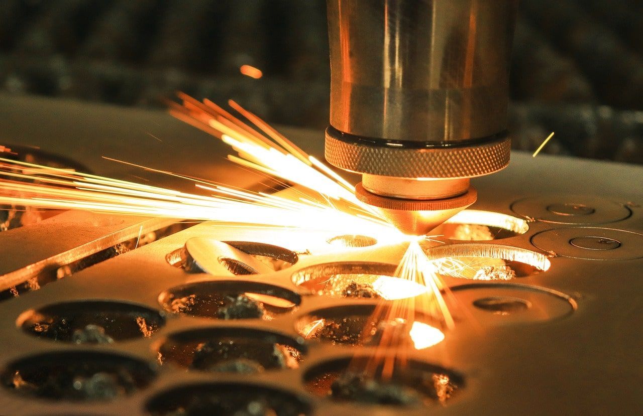A machine is cutting a piece of metal with a lot of sparks coming out of it.