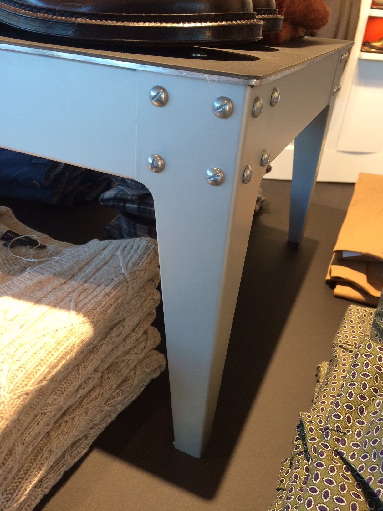 A white table with a bunch of clothes on it.