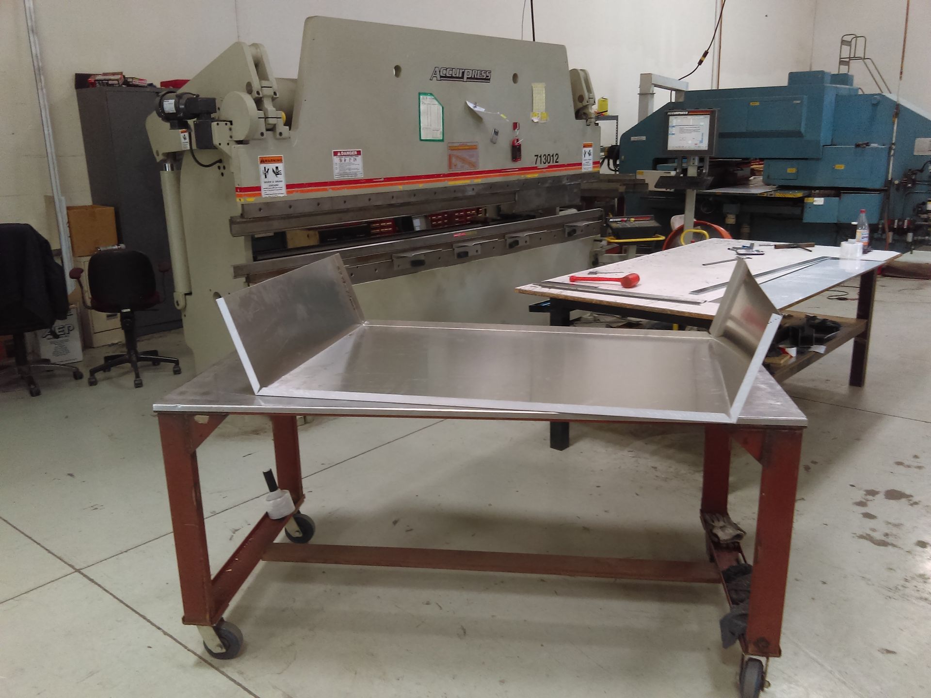 A stainless steel table in a factory with a machine in the background.