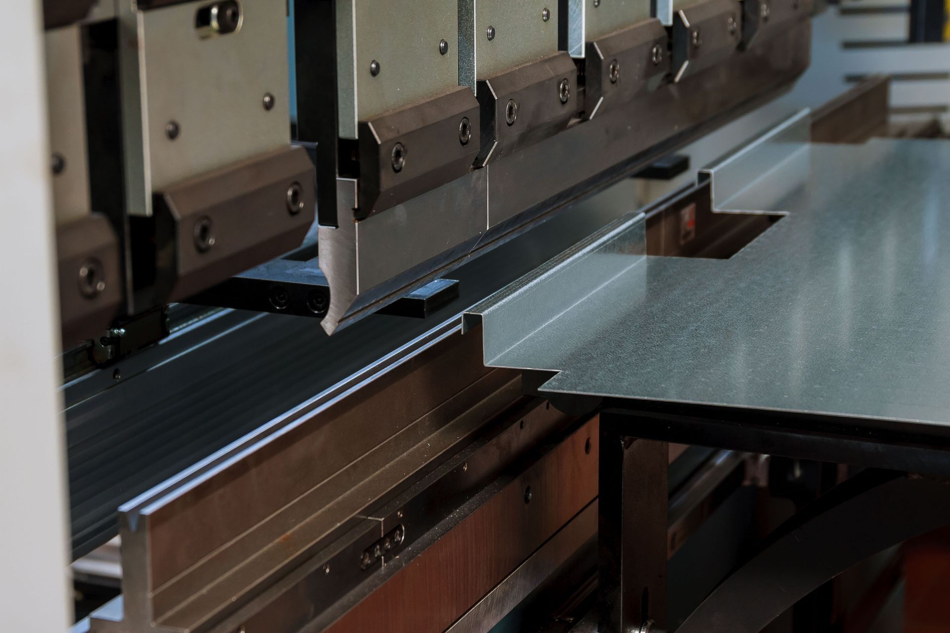 A machine is cutting a piece of metal in a factory.
