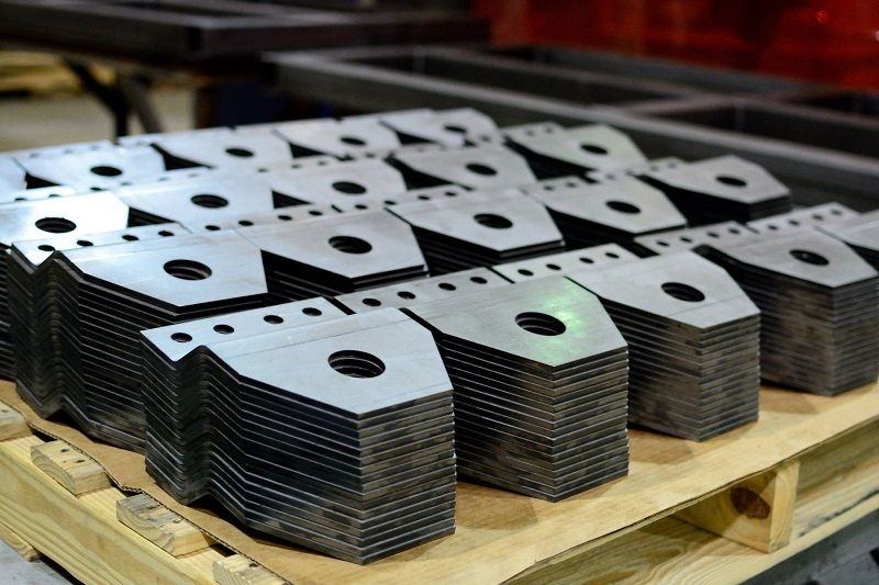 A wooden pallet with a bunch of metal pieces on it.