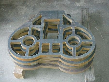 A stack of pieces of metal sitting on top of each other on a wooden pallet.