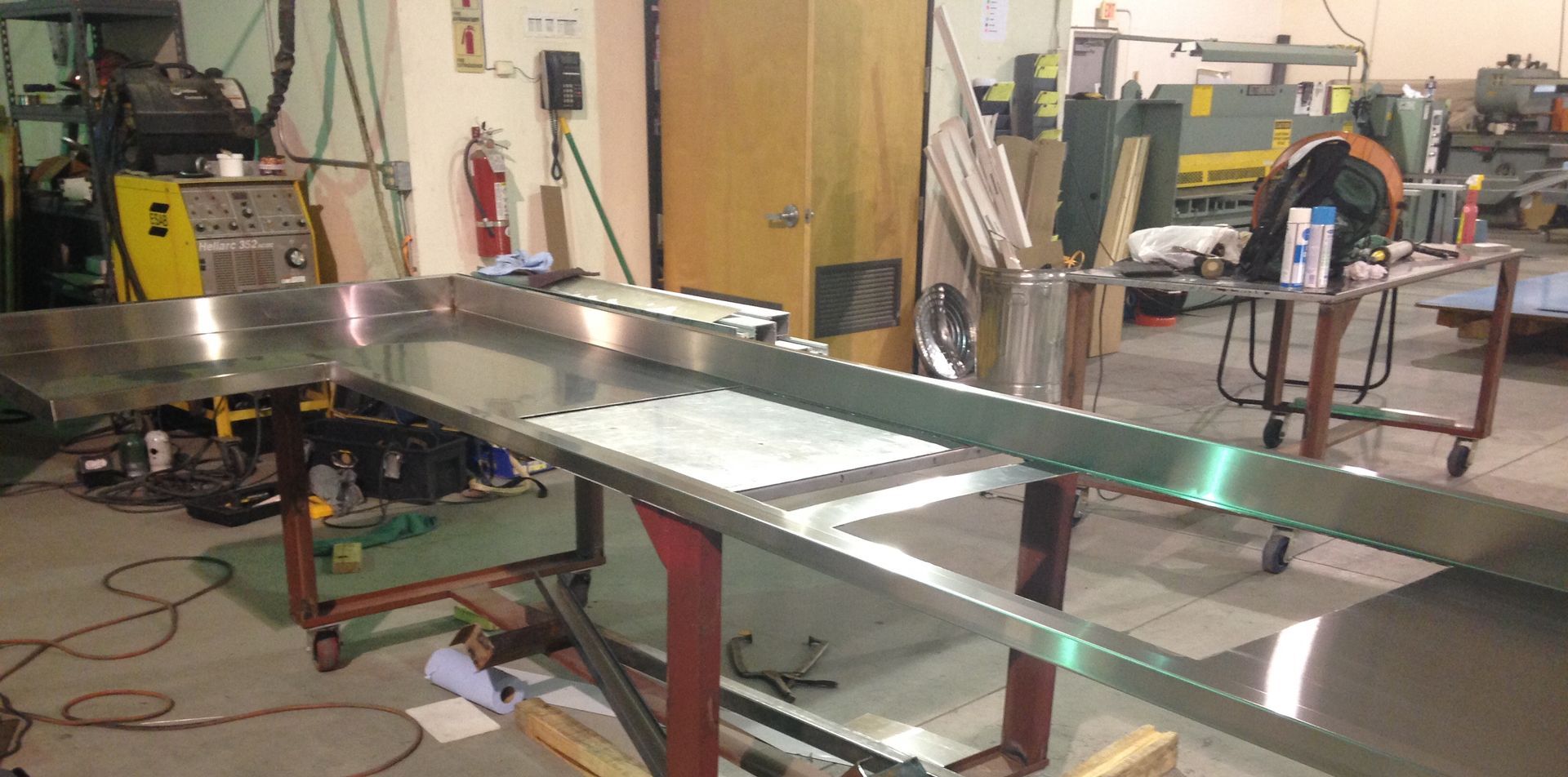 A stainless steel table is being built in a factory.