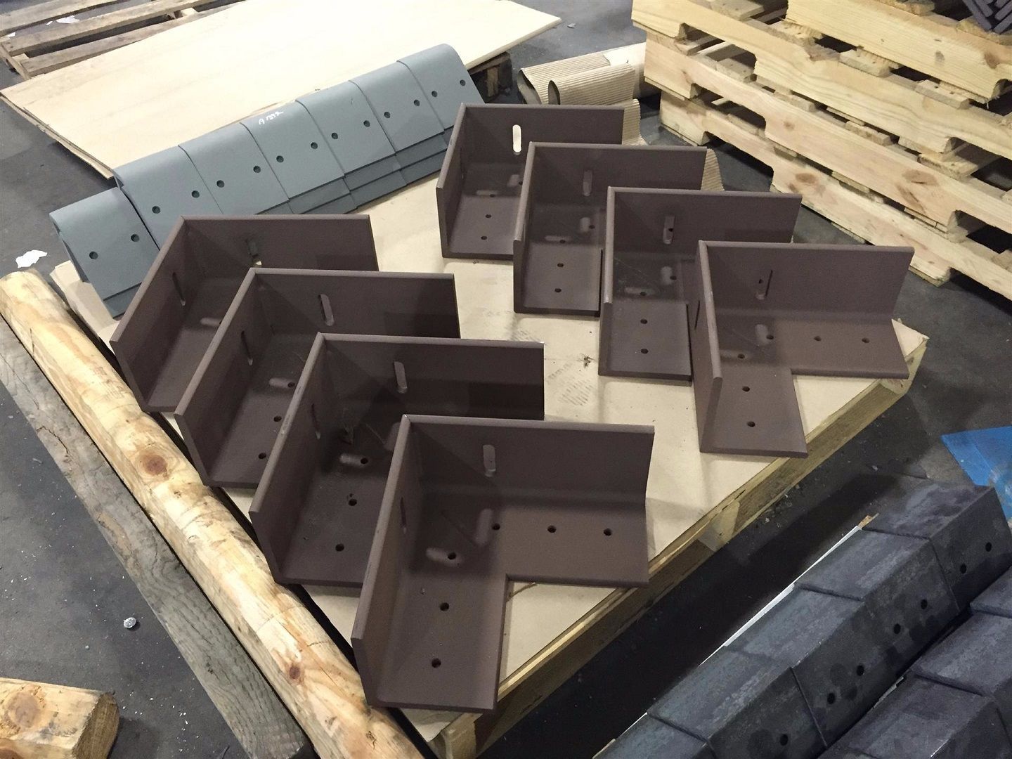 A bunch of metal pieces are sitting on a wooden pallet.