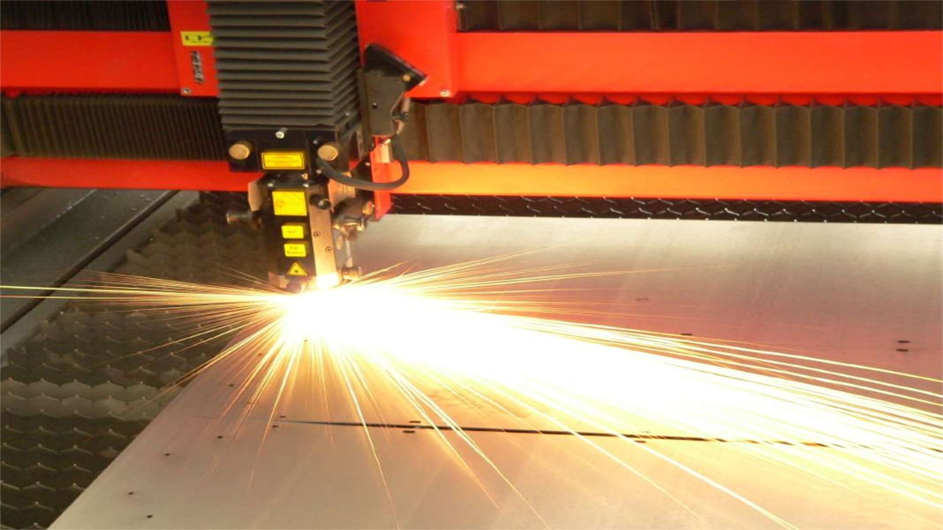A machine is cutting a piece of metal with a lot of sparks coming out of it.