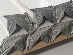 A close up of a stack of white sheets of paper on a wooden table.