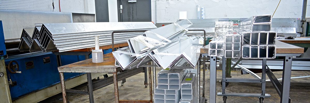 A bunch of metal pieces are sitting on a table in a factory.