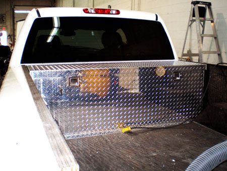 A white truck with a metal box in the bed.