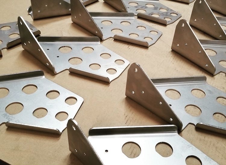 A bunch of metal pieces with holes in them on a table.