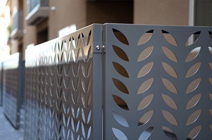 A metal fence with a pattern of leaves on it.