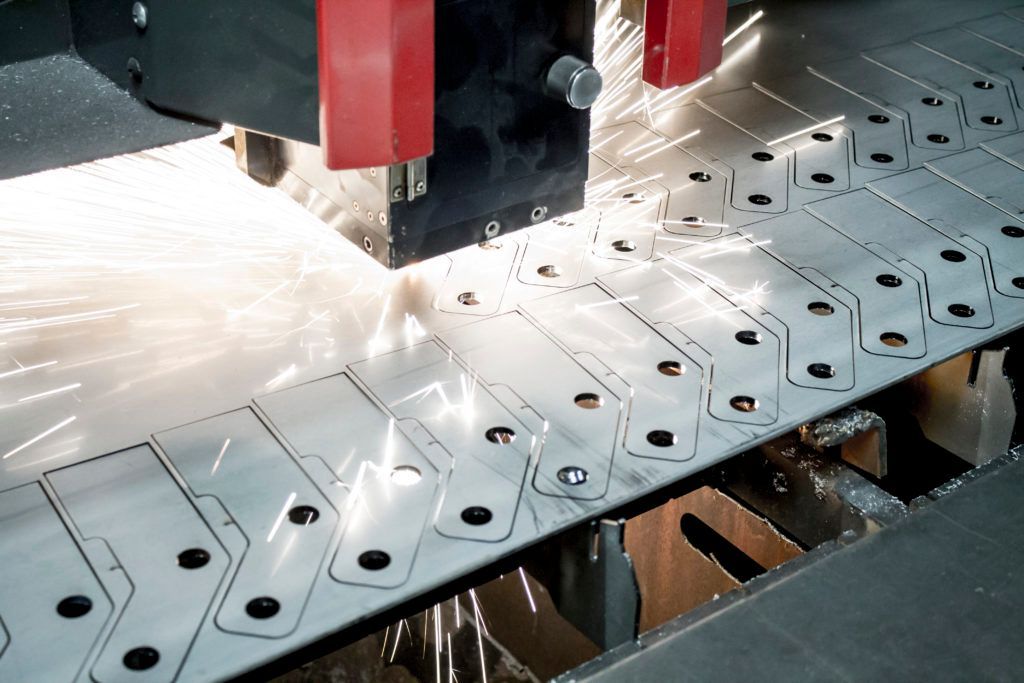 A machine is cutting a piece of metal with a lot of sparks coming out of it.