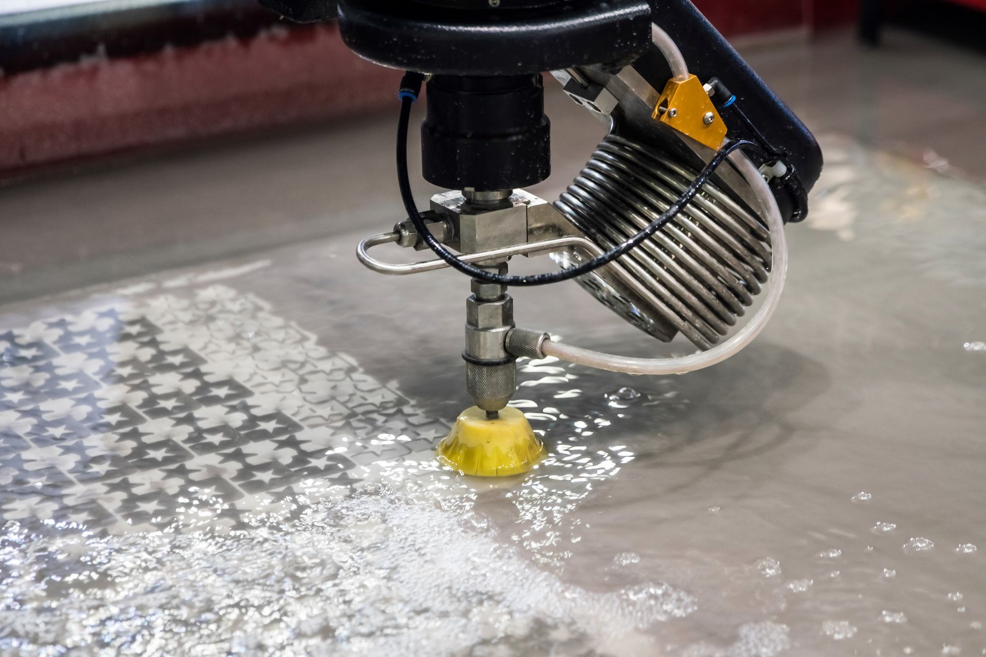 A machine is cutting a piece of metal with water.