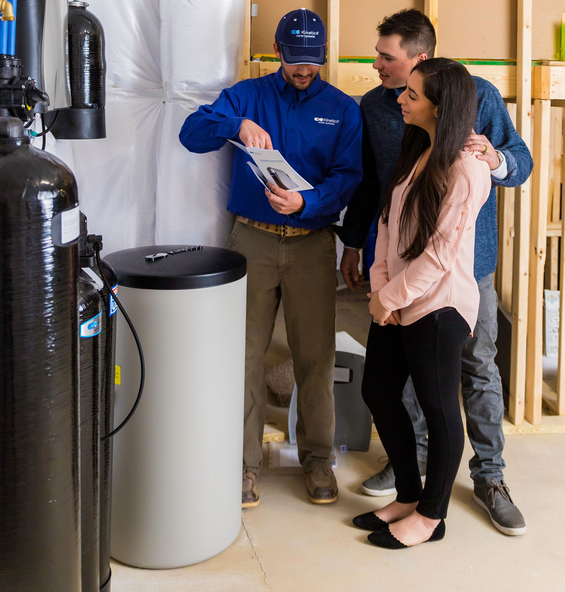 Water softener system installer showing paperwork to a couple.