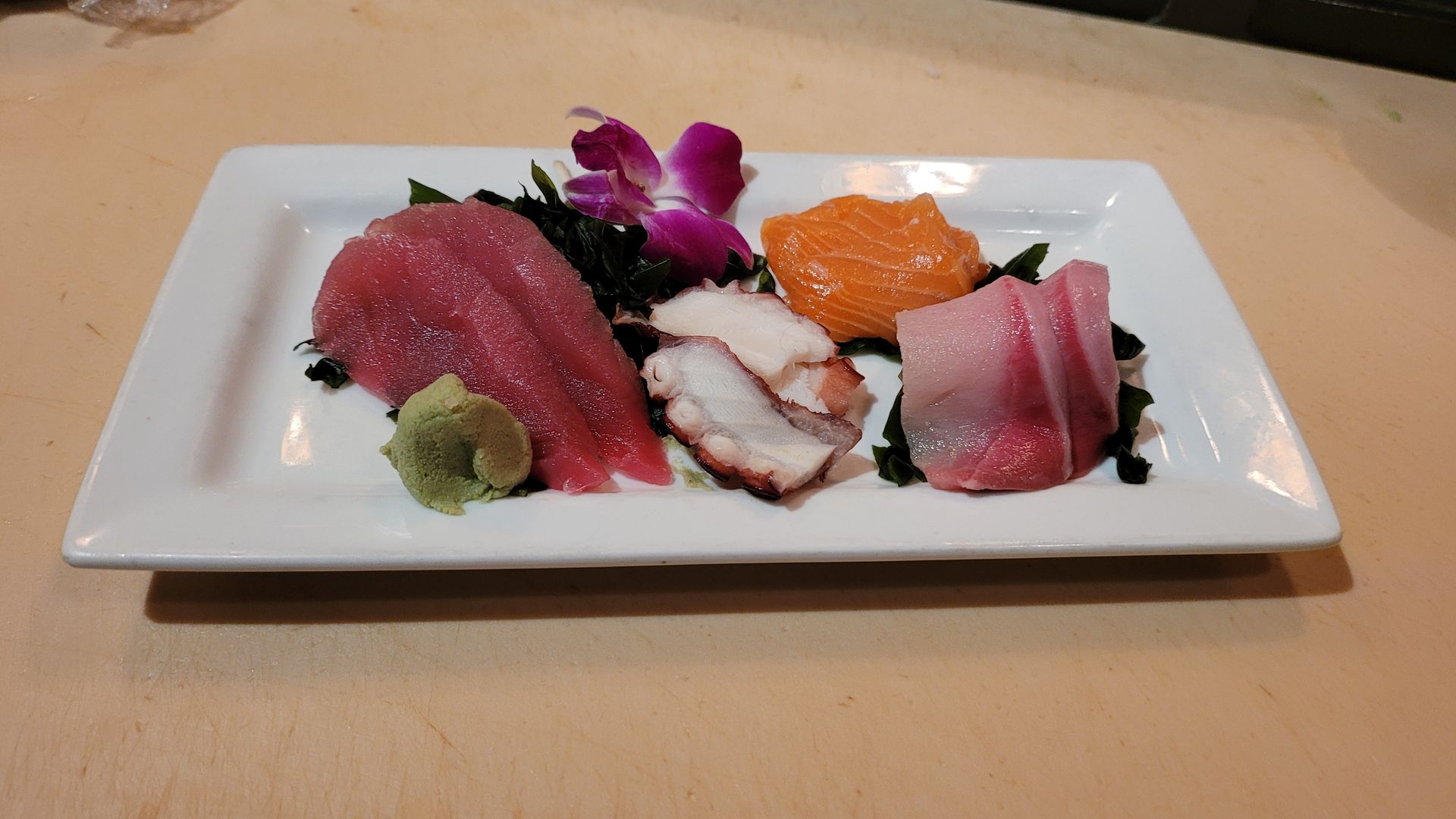 A white plate topped with a variety of sushi rolls.
