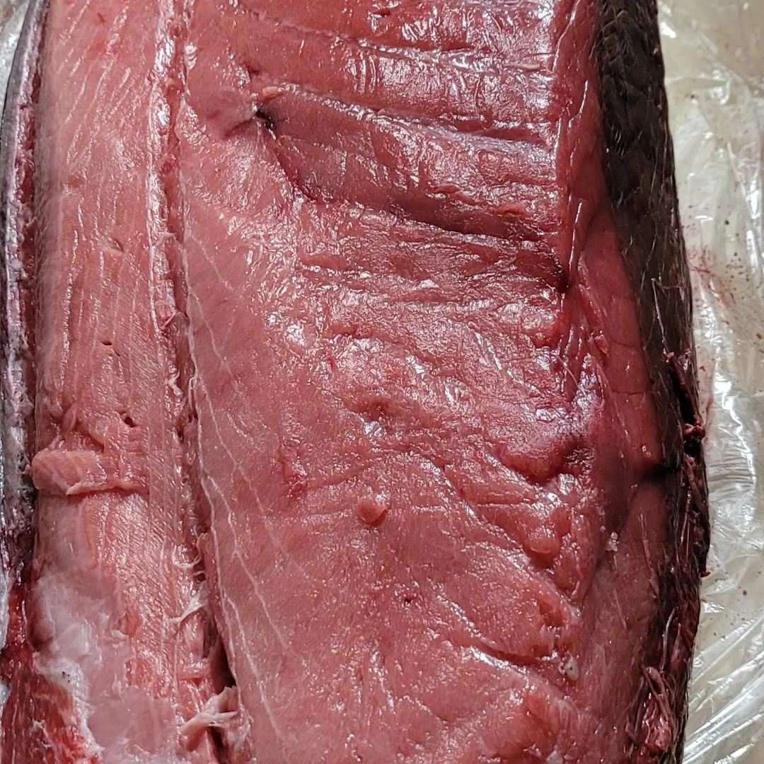 A close up of a piece of red meat wrapped in plastic.