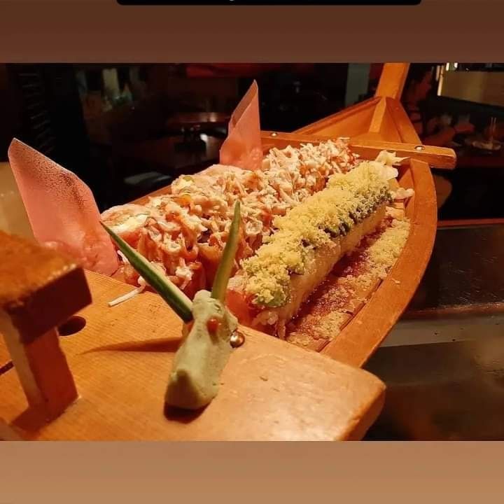 A wooden boat filled with a variety of food