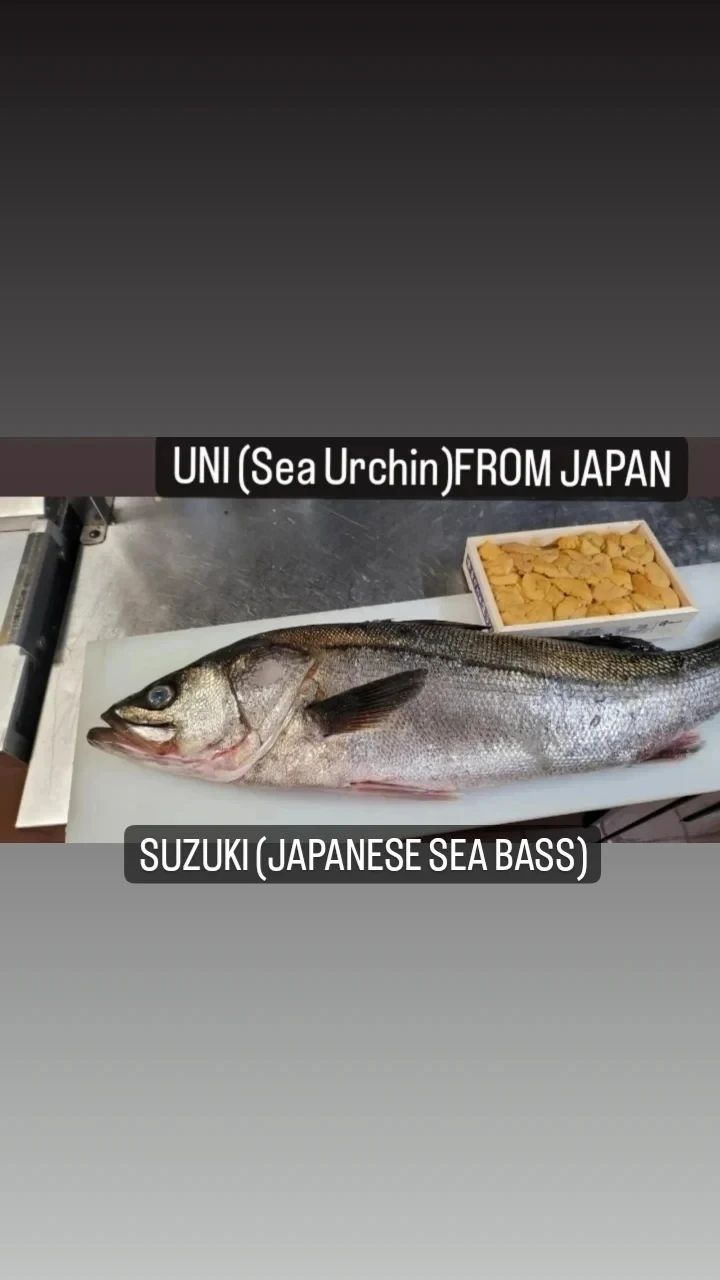 A large fish is sitting on top of a cutting board.