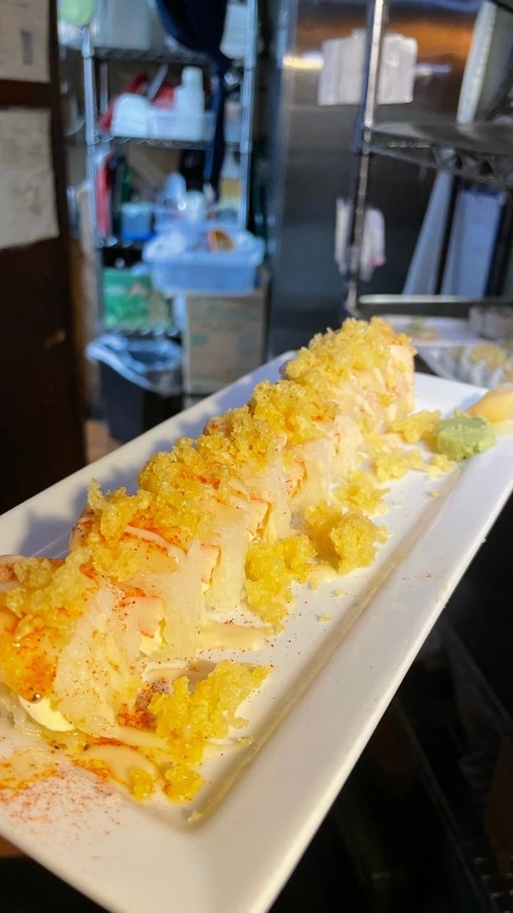 A white plate topped with a long piece of food in a kitchen.