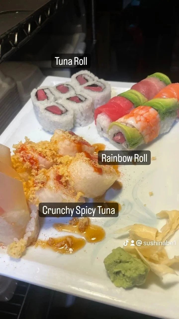 A plate of sushi with tuna roll rainbow roll and crunchy spicy tuna