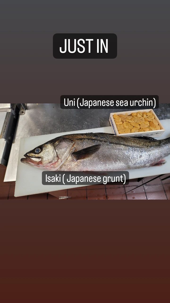 A large fish is sitting on a cutting board.