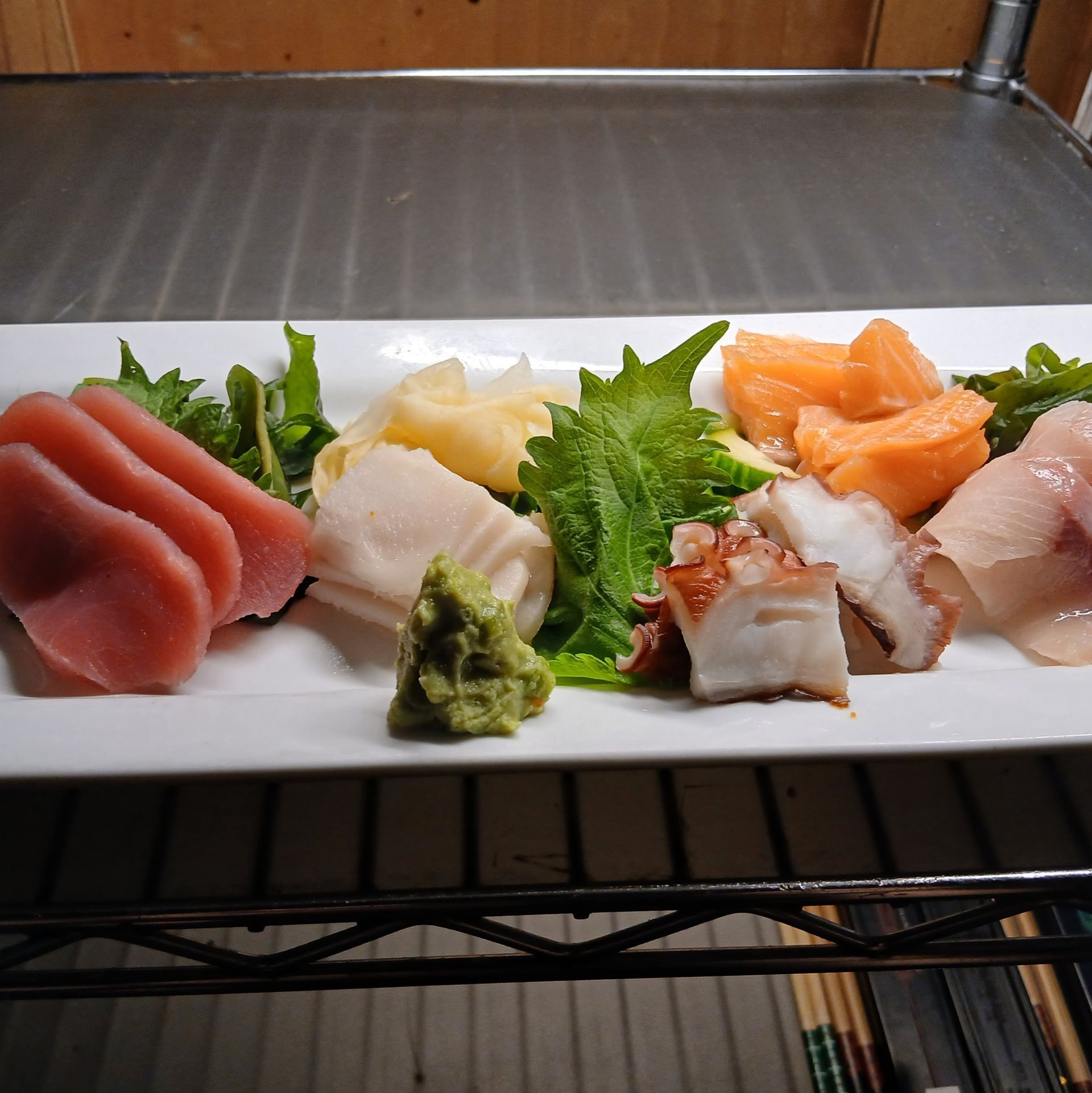 A white plate topped with a variety of meats and vegetables