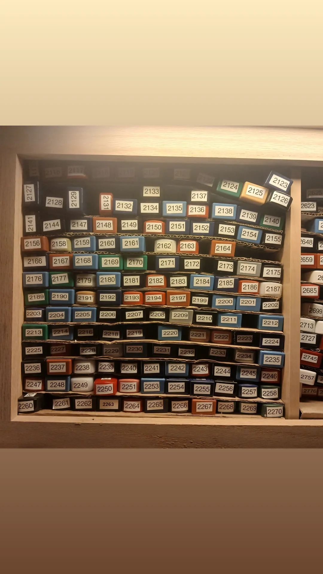 A shelf filled with lots of different colored boxes.