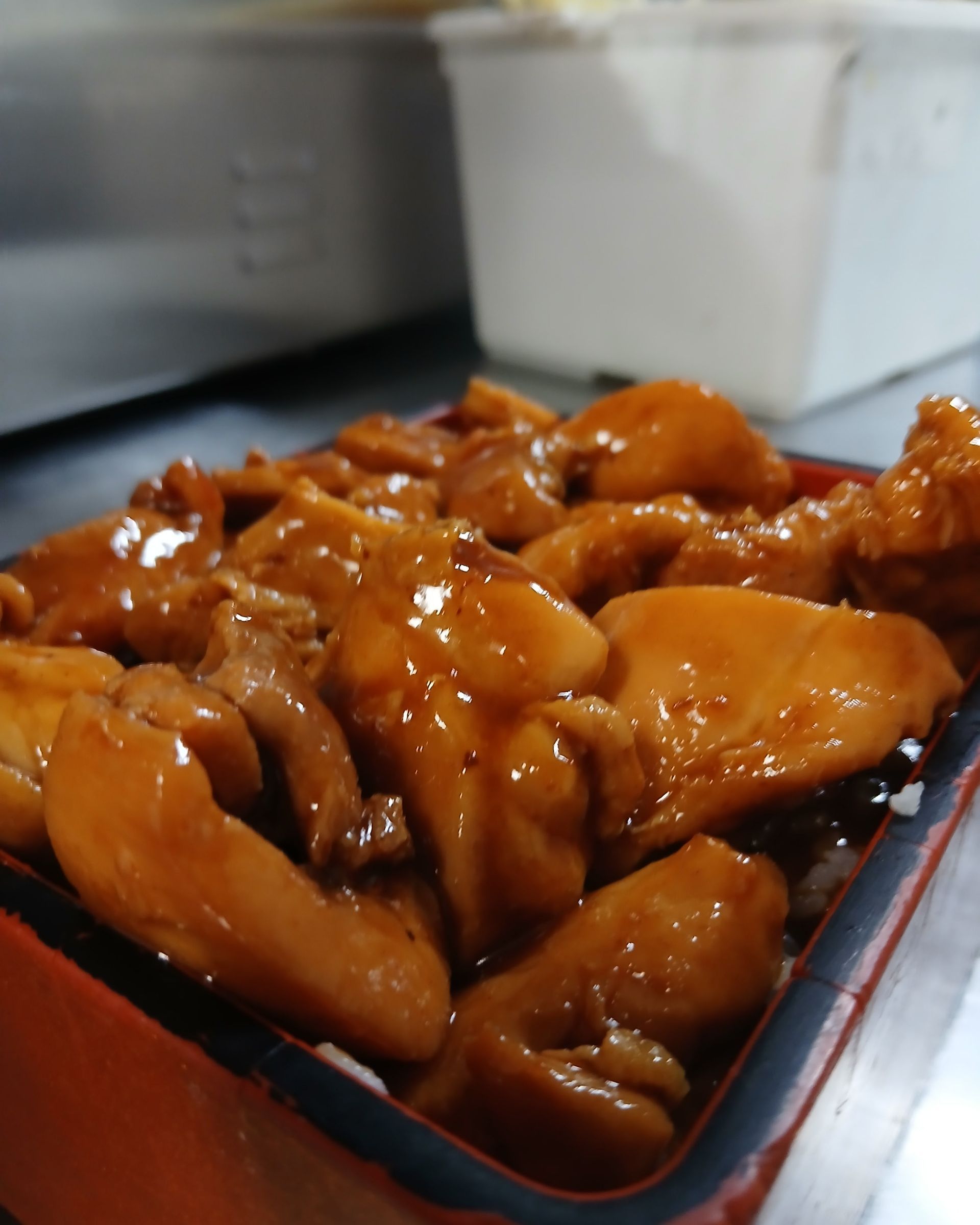A close up of a tray of chicken in a sauce