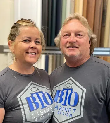 Two people wearing matching gray shirts with logo 