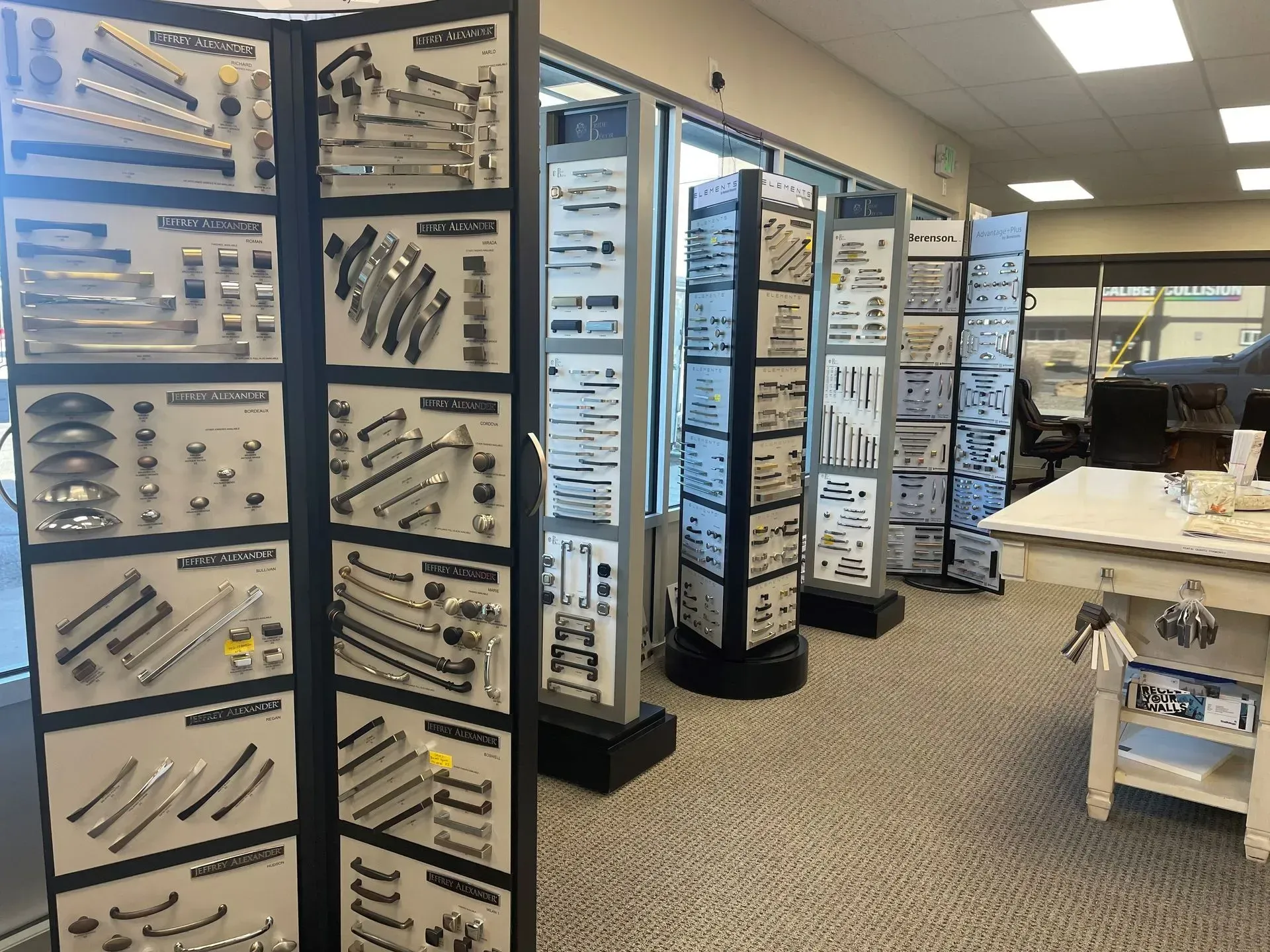 Display of cabinet hardware in a store. Several revolving displays feature knobs, pulls, and handles.