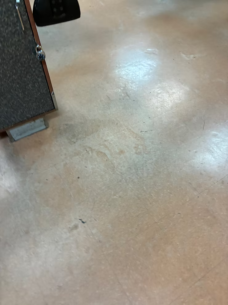 Polished tan floor beside a dark cabinet with reflected ceiling lights
