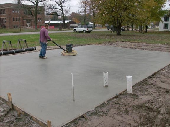 A man is using a machine to level a concrete surface.