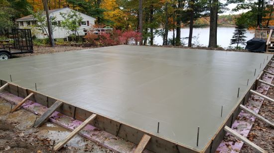 A large concrete slab is being built next to a lake.
