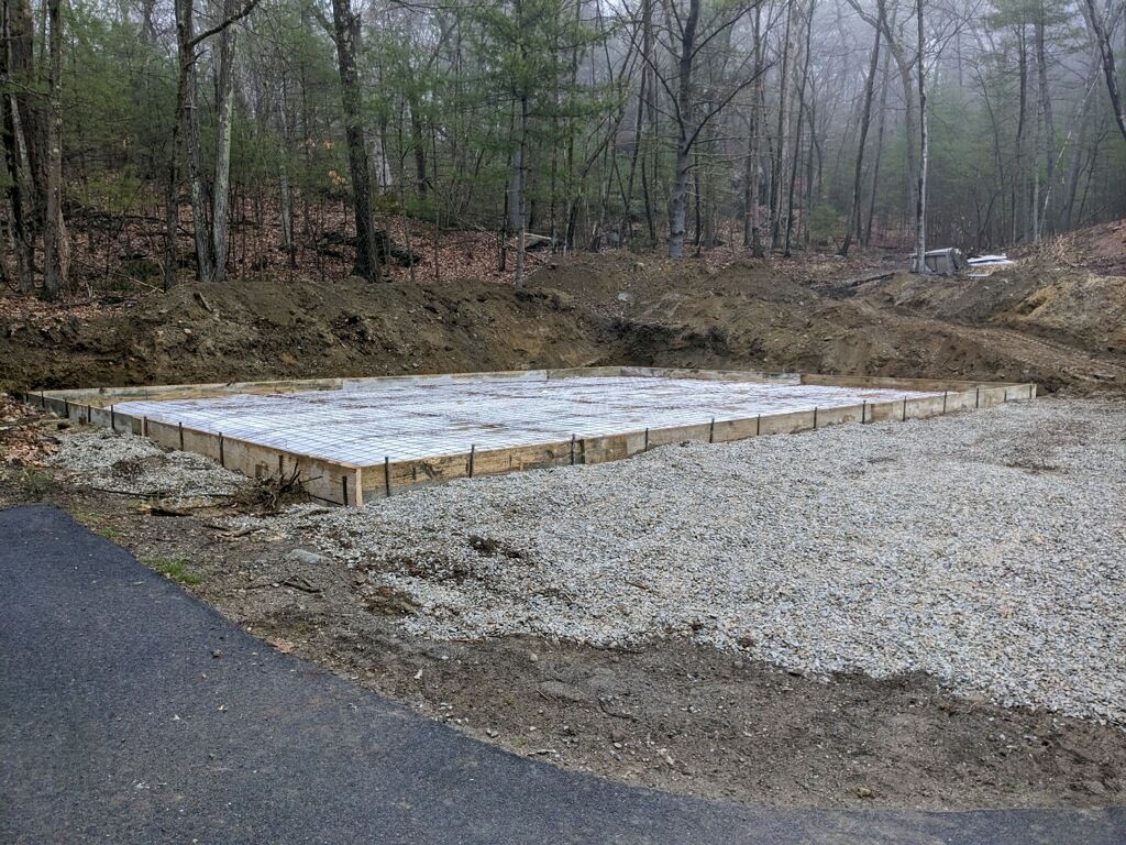 A concrete foundation is being built in the middle of a forest.