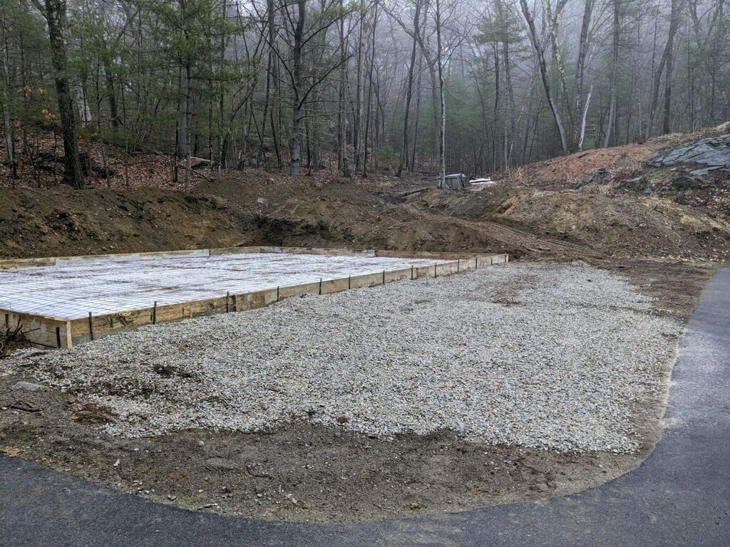 A concrete foundation is being built in the middle of a forest.
