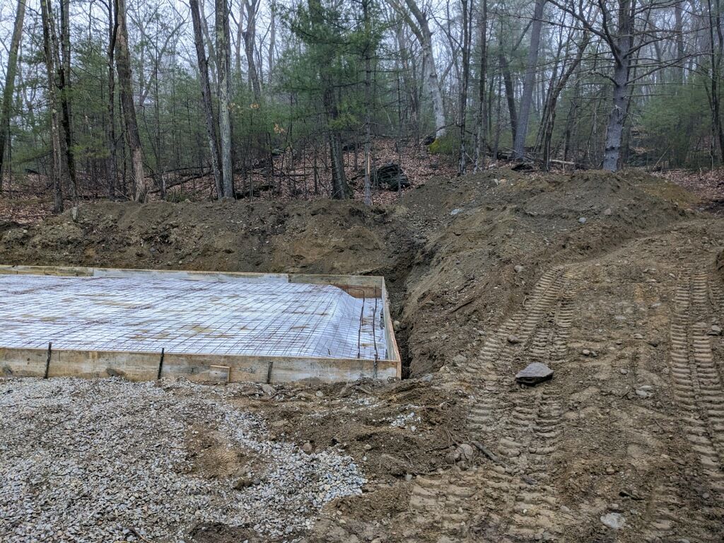 A concrete foundation is being built in the middle of a forest.