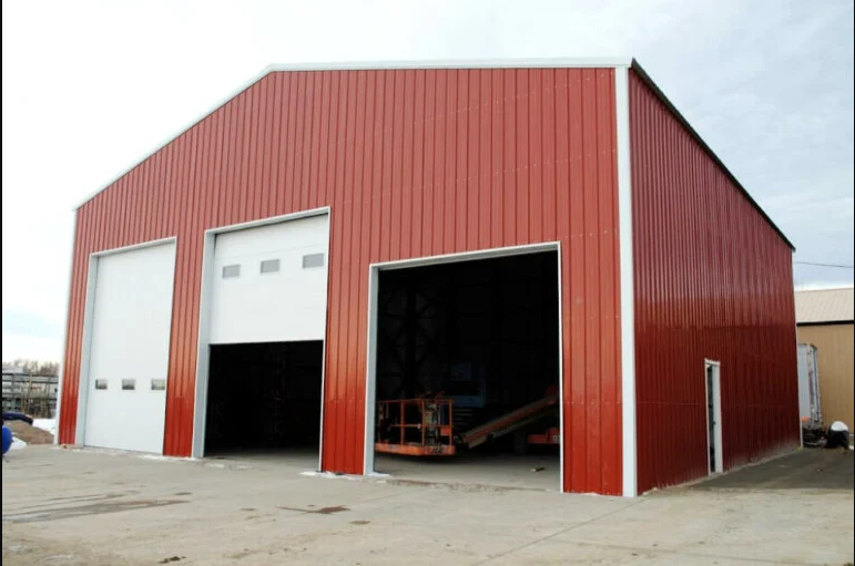 A red building with white doors and a lift in the garage.