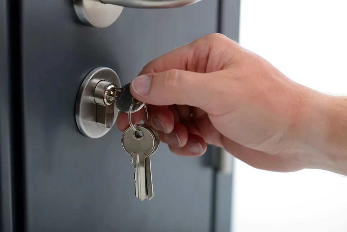 A person is locking a safe with a key.