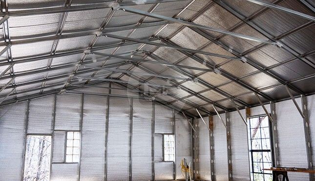 The inside of a building with a metal roof and a lot of windows.