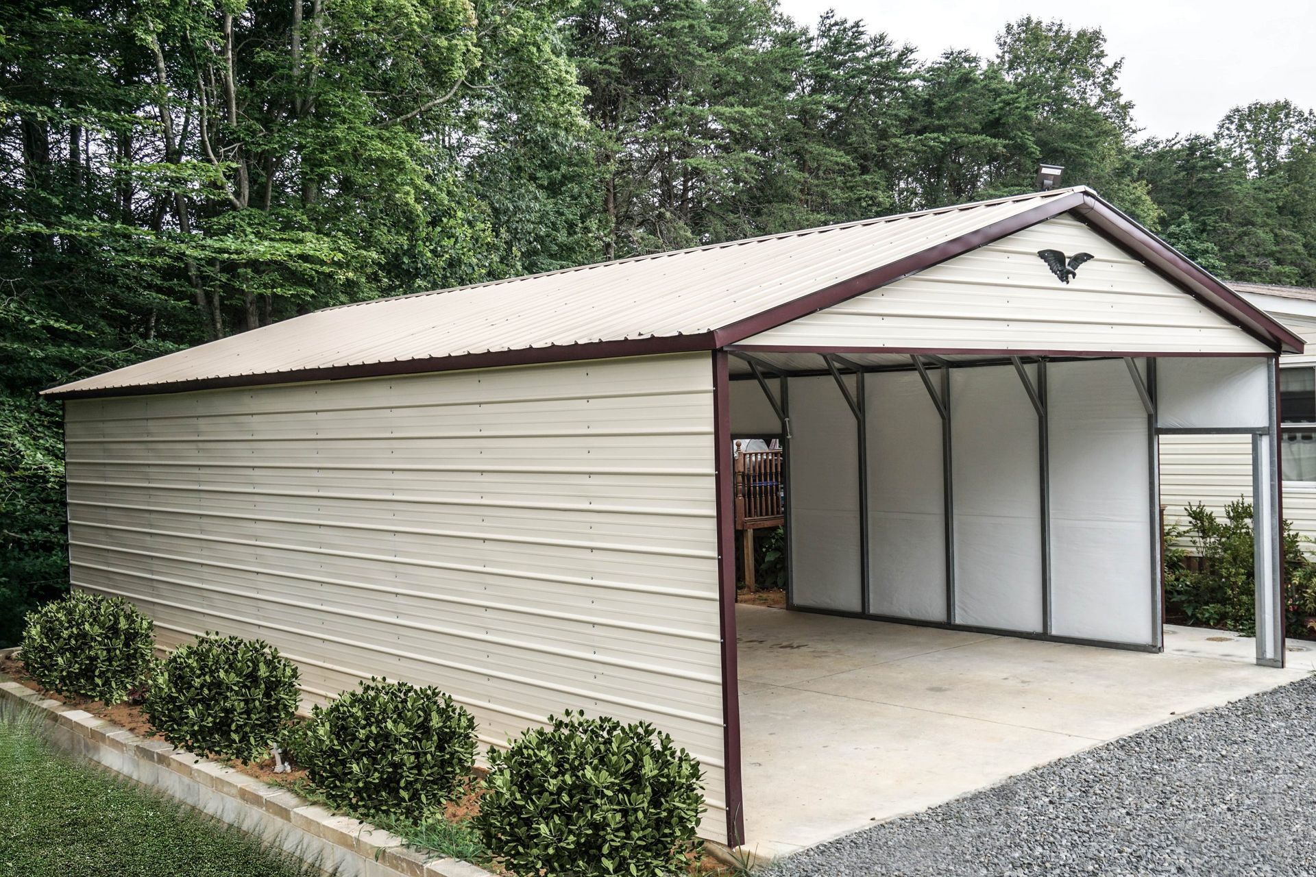 A white metal garage with a brown roof and a bird on the roof.